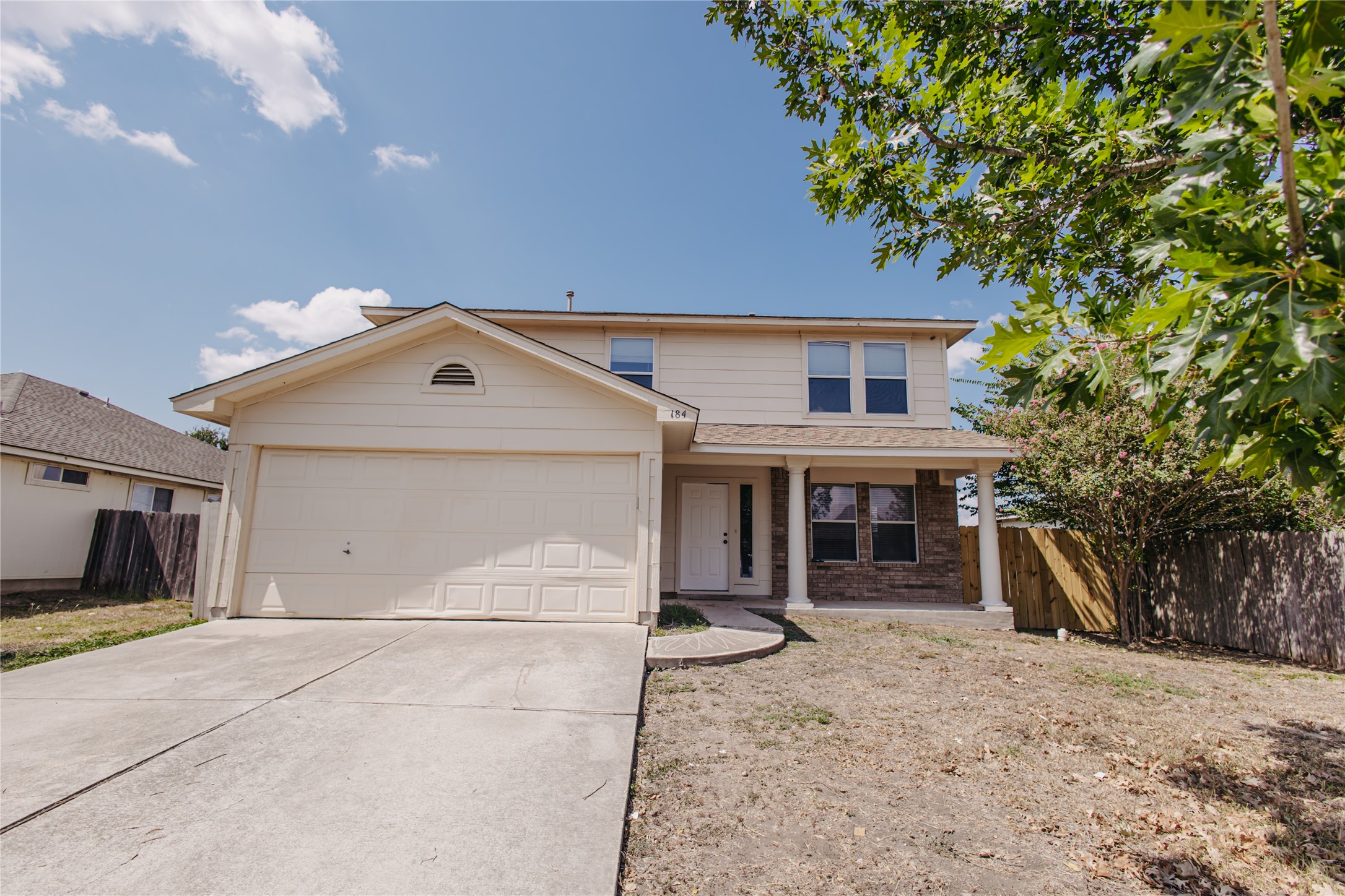 a view of a house with a yard and large tree