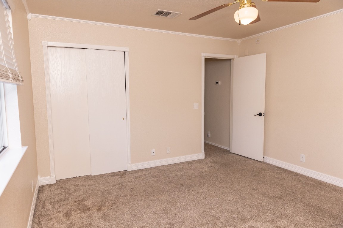 184 Unity Kyle, TX 78640 - Photo 13 of 33 Unfurnished bedroom featuring crown molding, carpet floors, a closet, and ceiling fan