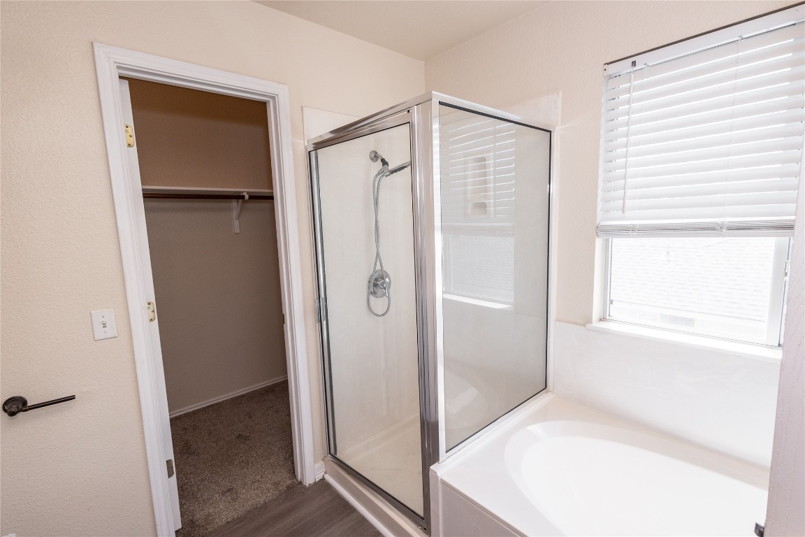 184 Unity Kyle, TX 78640 - Photo 16 of 33 Bathroom with a shower stall, a garden tub, a spacious closet, and dark wood-style flooring