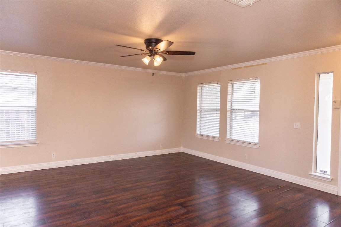 184 Unity Kyle, TX 78640 - Photo 27 of 33 Empty room with dark wood finished floors, crown molding, a ceiling fan, and a textured ceiling