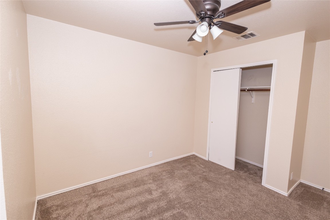 184 Unity Kyle, TX 78640 - Photo 30 of 33 Unfurnished bedroom with carpet flooring, a closet, and ceiling fan