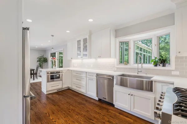 a kitchen with white cabinets and white appliances