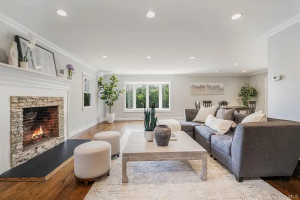 a living room with furniture a fireplace and a large window
