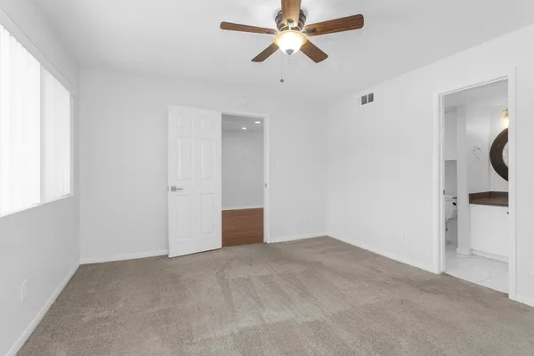an empty room with a window and a ceiling fan