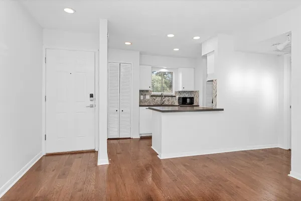 a view of an empty room and kitchen view