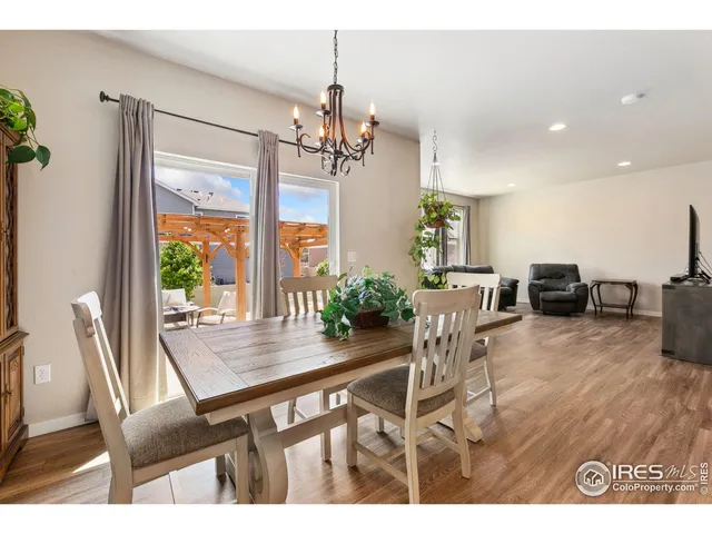 a dining room with furniture a chandelier and wooden floor
