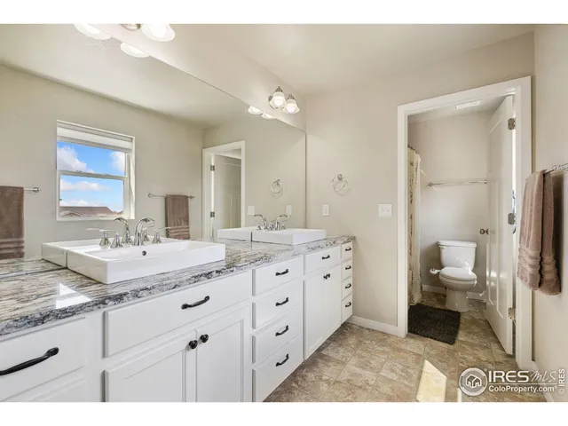 a bathroom with a granite countertop sink mirror and toilet
