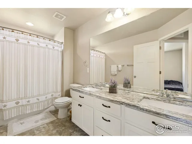 a bathroom with a granite countertop sink toilet a large mirror a shower and a bathtub