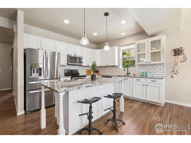 a kitchen with kitchen island white cabinets and stainless steel appliances