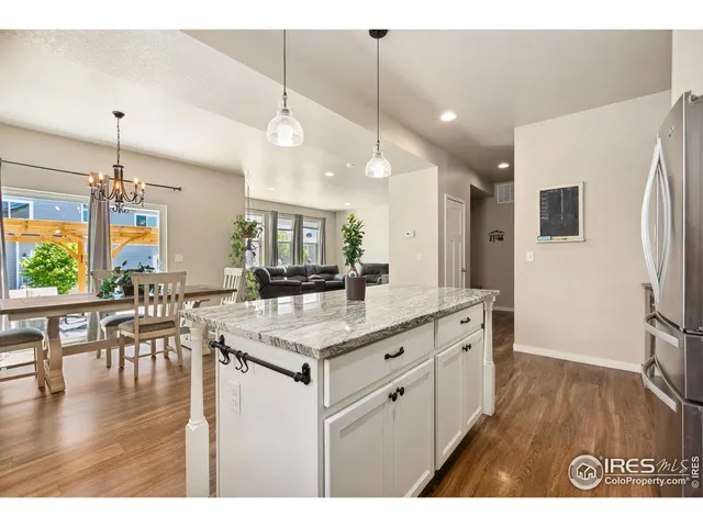 a kitchen with stainless steel appliances granite countertop a sink a stove and a wooden floor