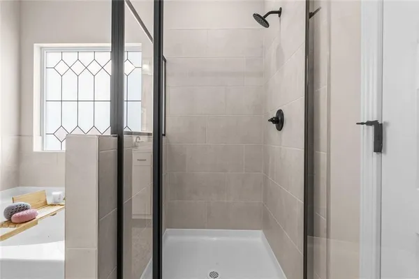 a en suite spacious bathroom with a tub double vanity and view bedroom