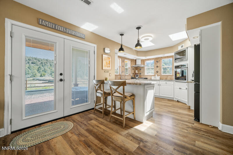 1931 Lousetown Road Reno, NV 89521 - Photo 8 of 51 a kitchen with stainless steel appliances a dining table chairs and wooden floors
