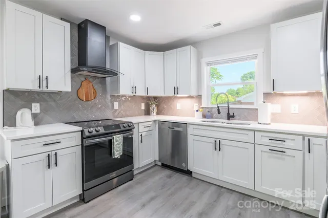 a kitchen with granite countertop white cabinets and white appliances