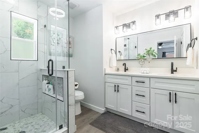 a bathroom with a double vanity sink mirror and shower