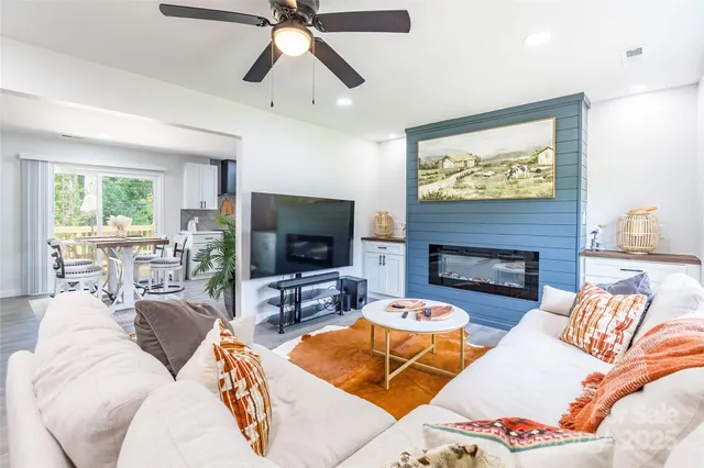 a living room with furniture a flat screen tv and a fireplace