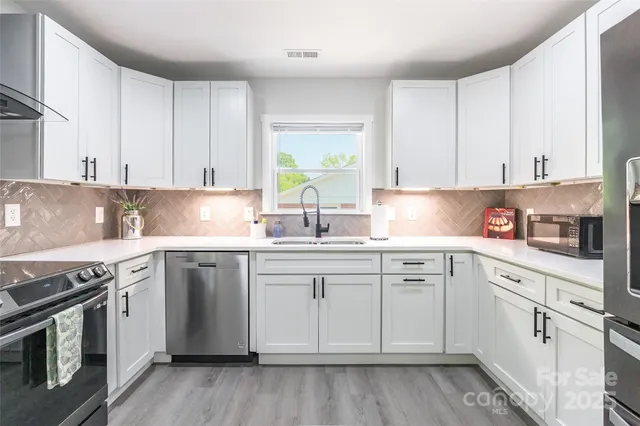 a kitchen with granite countertop white cabinets and white appliances
