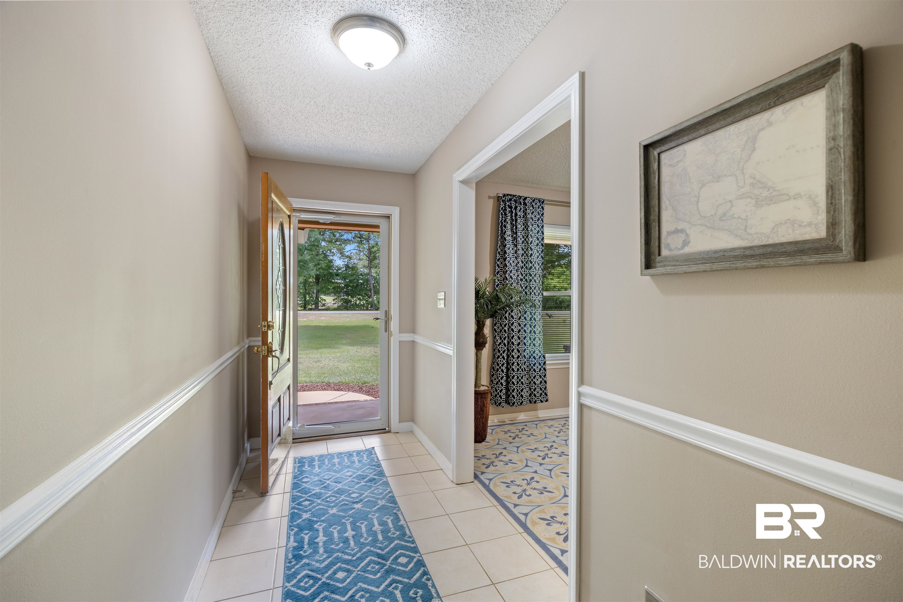 9771 Clarke Ridge Road Foley, AL 36535 - Photo 58 of 72 Doorway featuring a textured ceiling, baseboards, and light tile patterned floors.