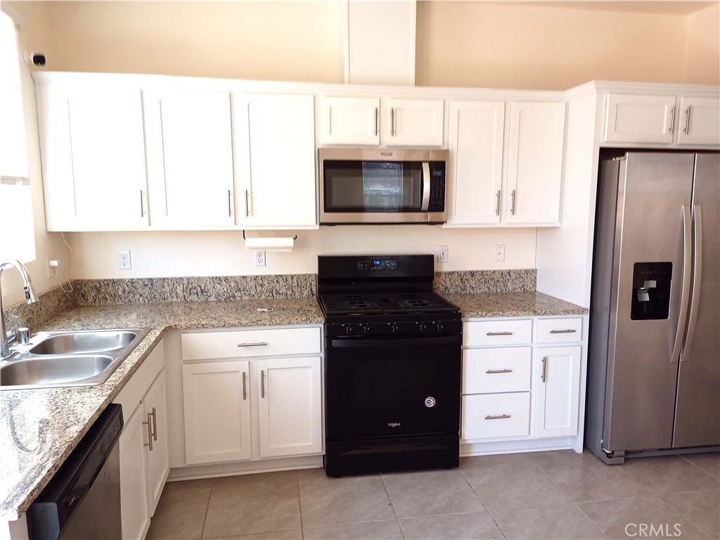 4244 Rutherford Avenue Merced, CA 95348 - Photo 6 of 23 a kitchen with white cabinets and stainless steel appliances