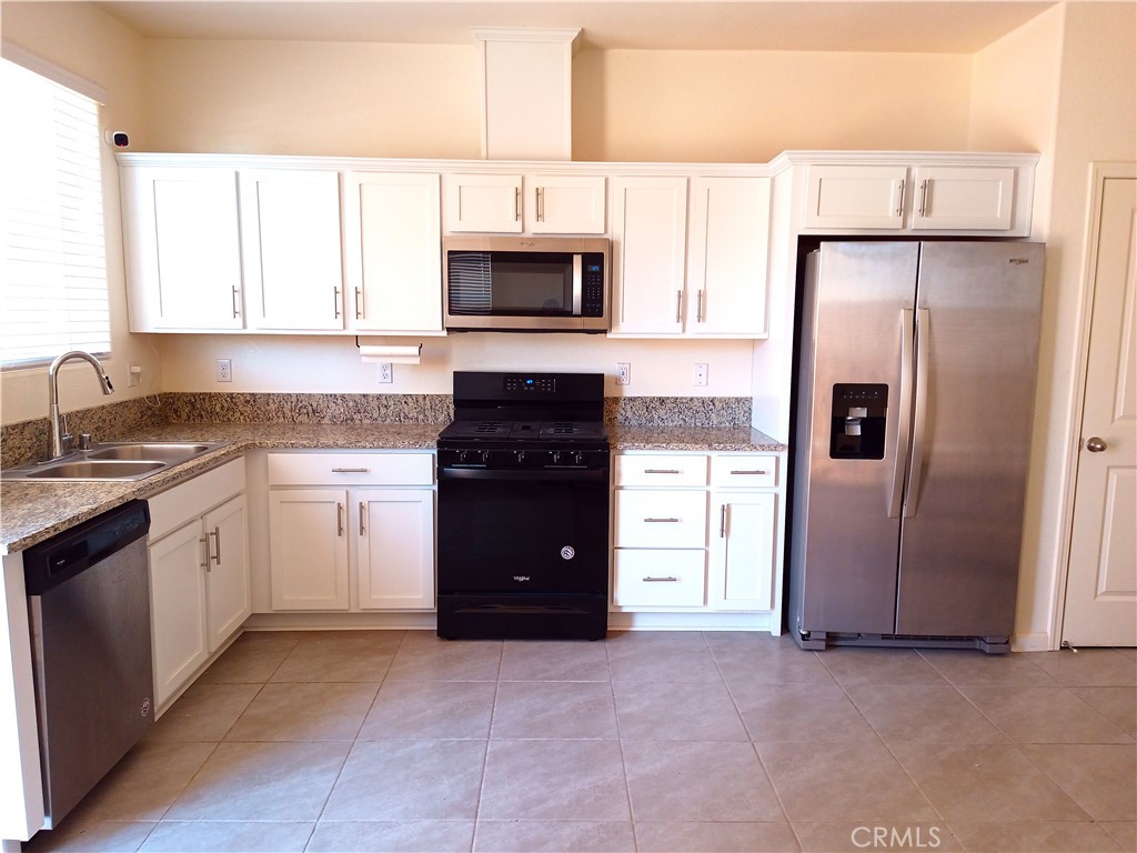 4244 Rutherford Avenue Merced, CA 95348 - Photo 7 of 23 a kitchen with a refrigerator sink and cabinets