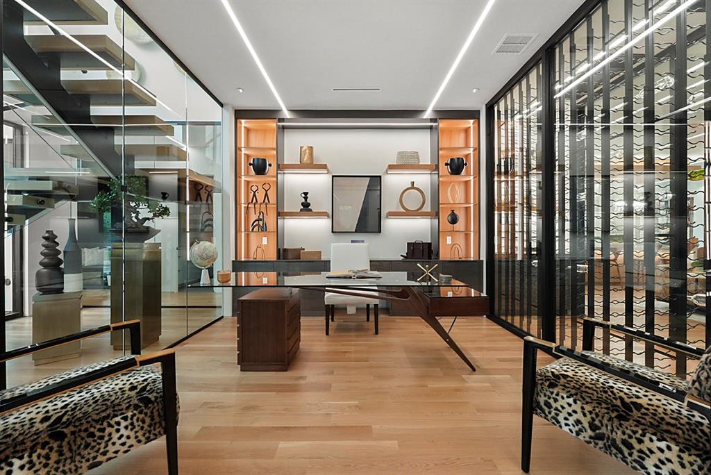 9457 Waterview Road Dallas, TX 75218 - Photo 6 of 25 Open-concept office space featuring light wood-finish flooring, recessed linear lighting, built-in shelving with integrated illumination, a glass-enclosed wine storage system, and a glass partition wall