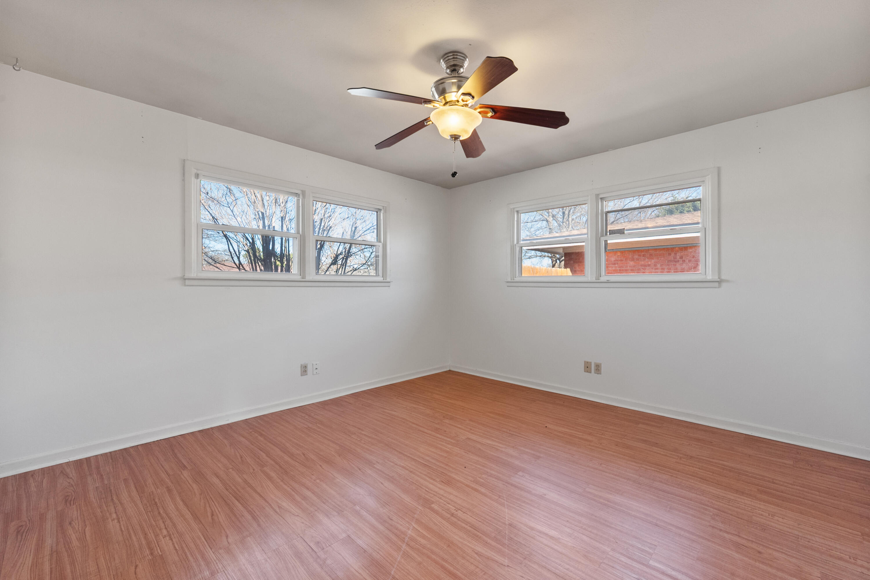 2509 61st Street Lubbock, TX 79413 - Photo 15 of 21 a view of an empty room with wooden floor and a ceiling fan