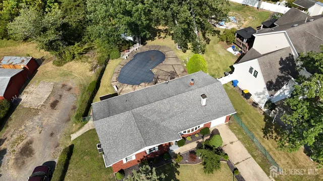an aerial view of a house with a yard and mountain view in back
