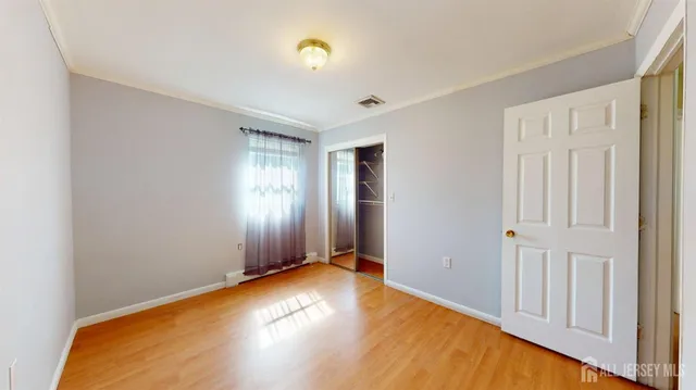 a view of empty room with wooden floor