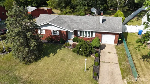 a aerial view of a house with a yard and potted plants