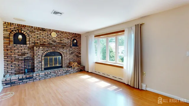 a view of an empty room with a fireplace and a window