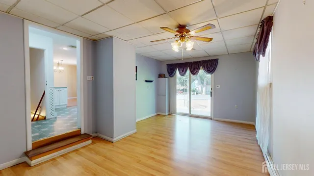 a view of an empty room with window and wooden floor