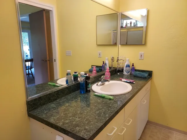 a bathroom with a granite countertop sink and a mirror