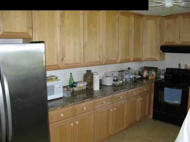 21 Awalau Road Haiku, HI 96708 - Photo 22 of 30 a kitchen with stainless steel appliances granite countertop a refrigerator a stove a sink and dishwasher with wooden floor