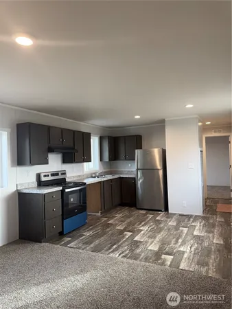 a large kitchen with stainless steel appliances granite countertop a refrigerator and a sink