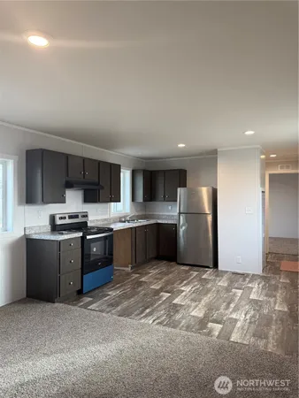 a large kitchen with a stove a refrigerator and a sink