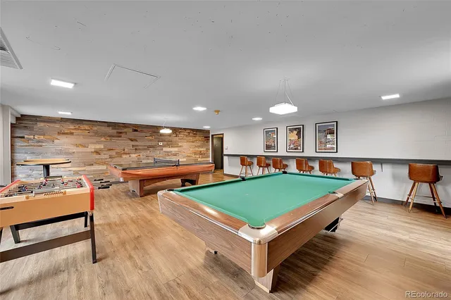 a living room with furniture pool table and flat screen tv