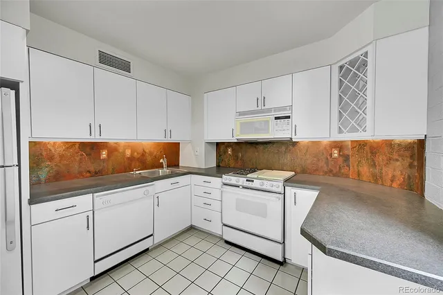 a kitchen with white cabinets appliances and sink