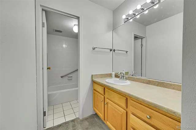 a spacious bathroom with a granite countertop sink a mirror and shower