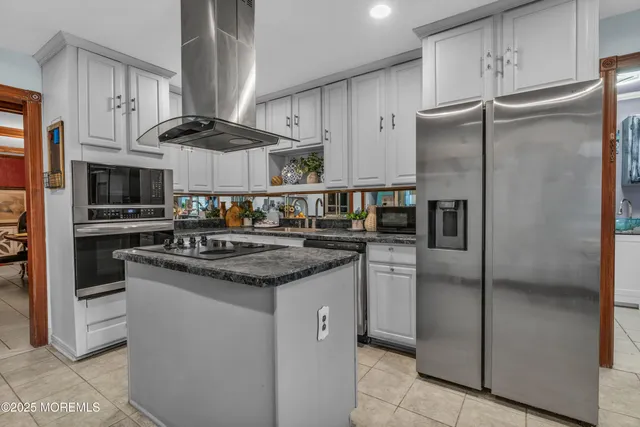 a kitchen with stainless steel appliances granite countertop a stove a refrigerator and a sink