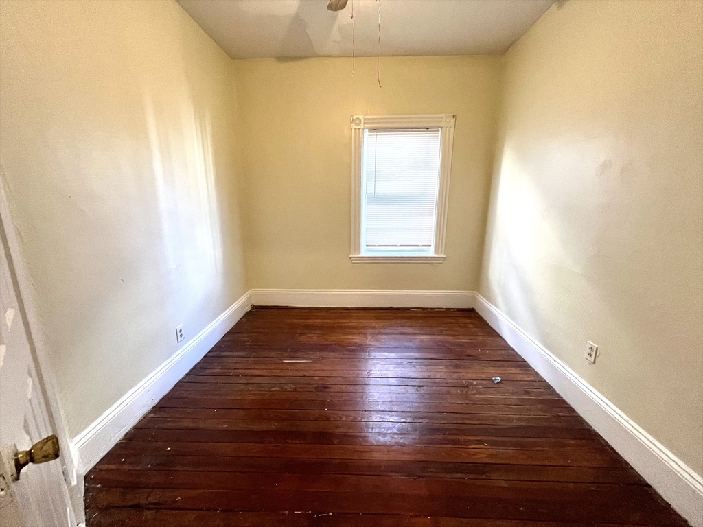 15 Wentworth Street, Unit 1 Boston, MA 02124 - Photo 11 of 14 a view of an empty room with wooden floor and a window