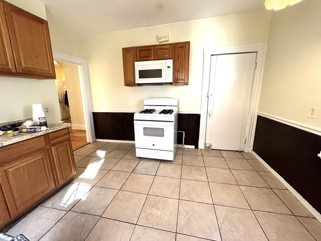 15 Wentworth Street, Unit 1 Boston, MA 02124 - Photo 12 of 14 a kitchen with a stove a refrigerator and cabinets