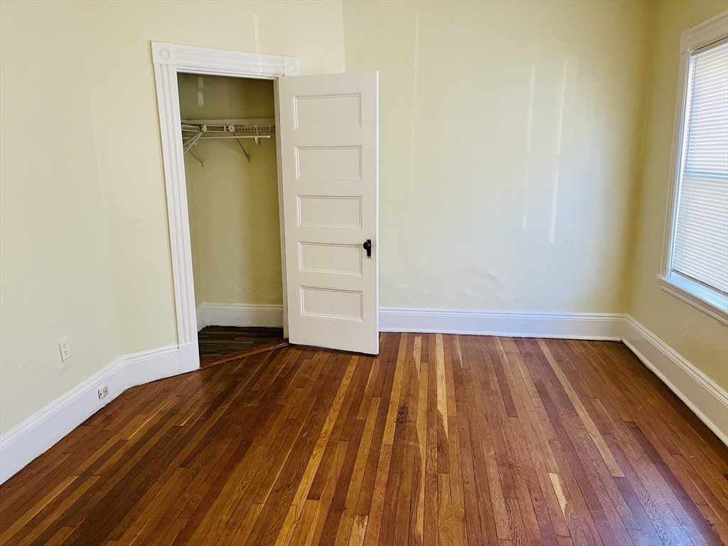 15 Wentworth Street, Unit 1 Boston, MA 02124 - Photo 3 of 14 a view of an empty room with wooden floor and a window