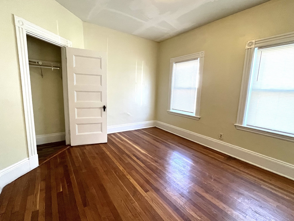 15 Wentworth Street, Unit 1 Boston, MA 02124 - Photo 4 of 14 an empty room with wooden floor and windows