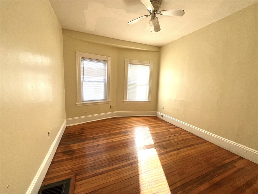 15 Wentworth Street, Unit 1 Boston, MA 02124 - Photo 8 of 14 a view of an empty room with wooden floor and a window