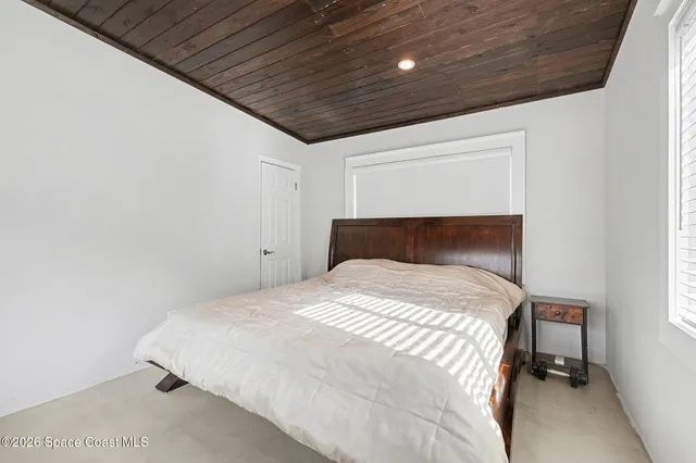 a bed sitting in a bedroom next to a window