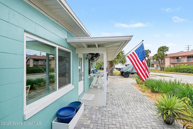 a living room with patio furniture and a potted plant