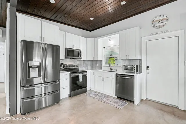 a kitchen with stainless steel appliances granite countertop a refrigerator stove and microwave