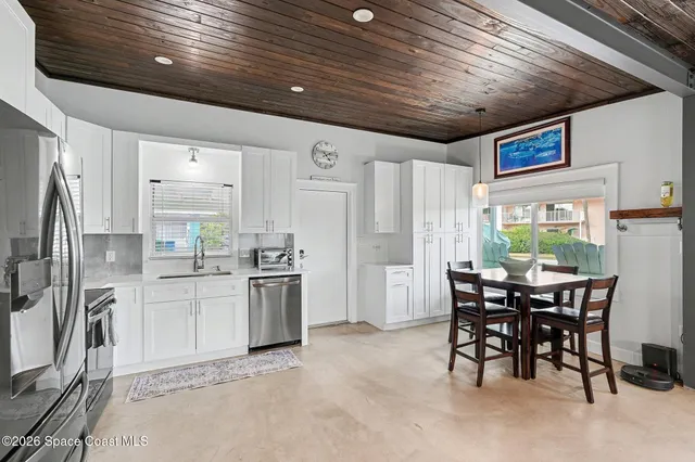 a kitchen with refrigerator cabinets dining table and chairs