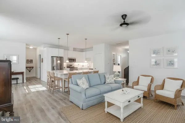 a living room with furniture and a view of kitchen