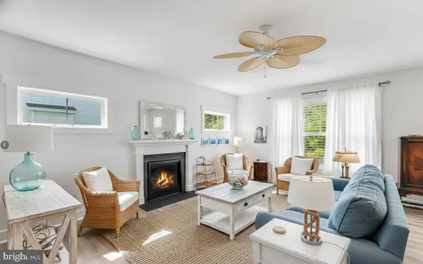 a living room with furniture a fireplace and a window