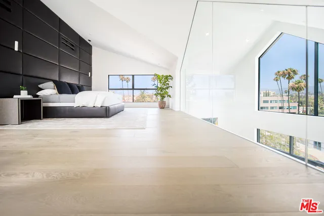 a bedroom with a large bed and a painting on the wall